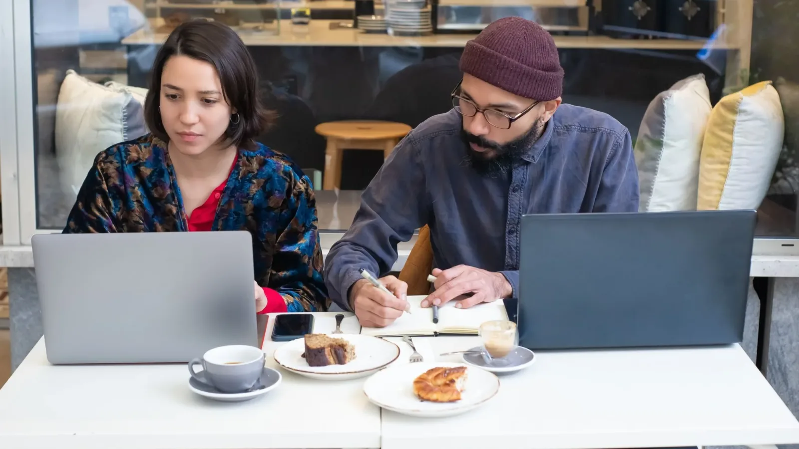 Business meeting over coffee with laptops in a cozy café. Collaboration and teamwork at a modern café table.